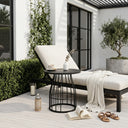 Outdoor seating area with a chair, small table, and plants on a wooden deck.