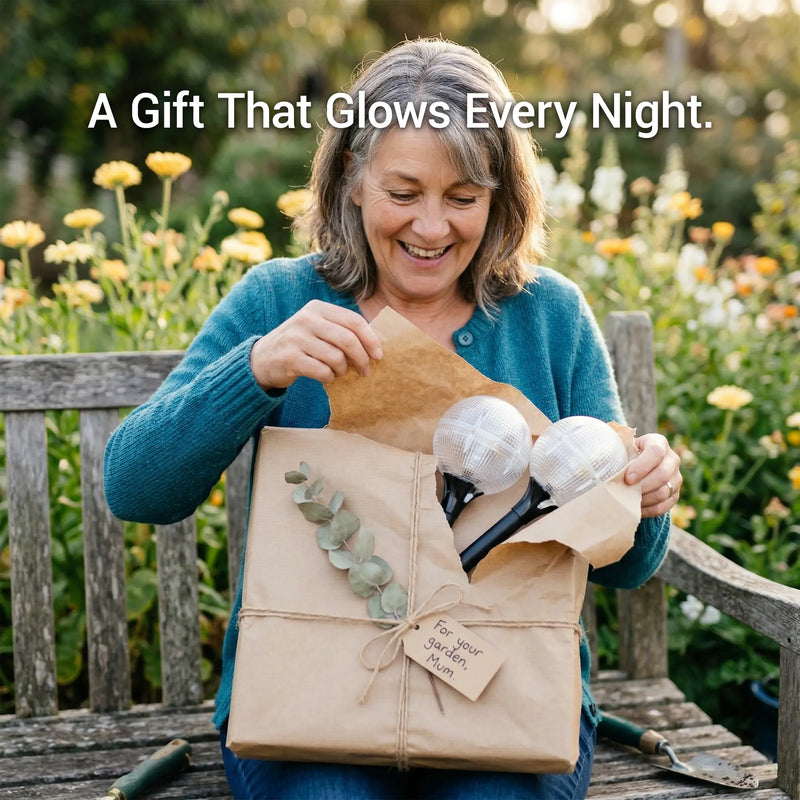 A happy woman unboxing a gift-wrapped set of solar globe lights with a tag that reads "For your garden, Mum."