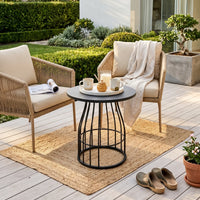 Outdoor seating area with two chairs, a small table, and a rug on a wooden deck.