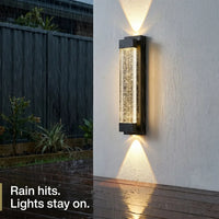 Outdoor wall light fixture on a wet wall with rain hitting the surface