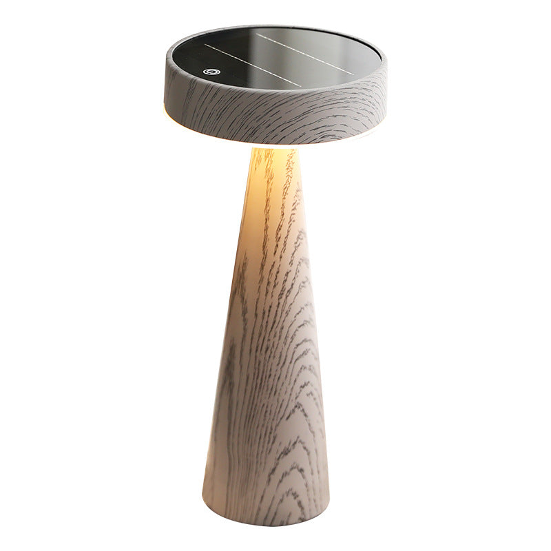 Wooden table lamp with a solar panel on top against a white background