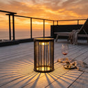 Sunset over a deck with a lit lantern and glass of wine.