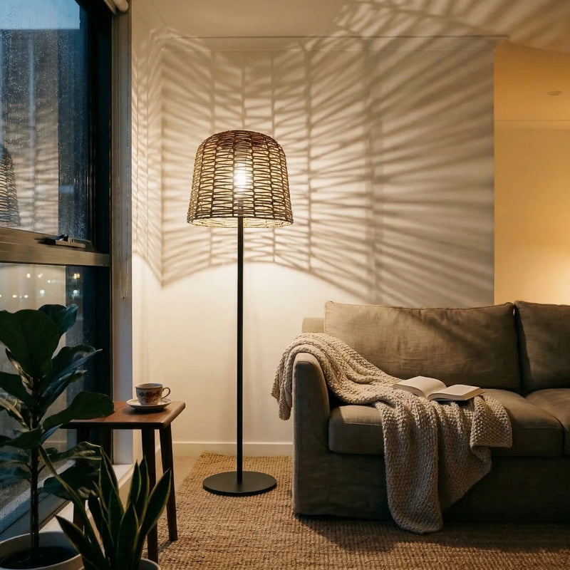 Indoor living room scene with lamp casting leaf-patterned shadows on wall — blends boho decor with cozy sofa and side table, proving versatility beyond patios into bedrooms and reading nooks.