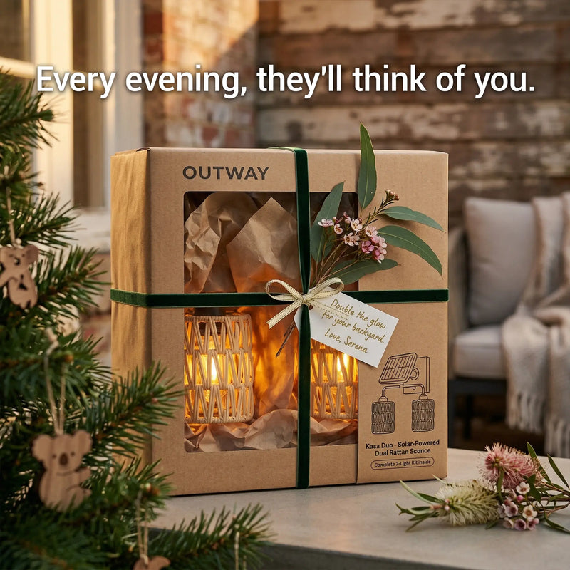 Gift box with a decorative item, tied with a green ribbon and floral elements, on a table with a cozy indoor background.