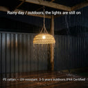 The PT0901 Kiku Solar Rattan Lantern glowing steadily in heavy rain, demonstrating its IP44 waterproof rating and durable UV-resistant PE rattan construction suitable for year-round outdoor use.