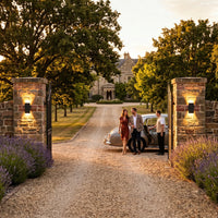 Elegant driveway entrance with PT0710 solar lights on stone pillars welcoming guests.