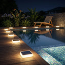 Lumterra PT0608 solar lights lining a wooden pool deck at night, reflecting beautifully in the water and enhancing the tropical garden atmosphere.