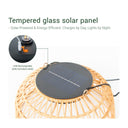 A handwoven ceiling light  topped with a solar-powered lamp.