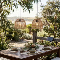 Outdoor dining setup with PT0914 lanterns over wooden table set for four, surrounded by native Australian flora — solar panel discreetly mounted on fence post.