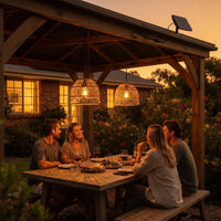 Group of four friends dining under PT0914 lanterns at sunset, wine glasses and food on table — reinforces product’s role in enhancing social outdoor experiences.