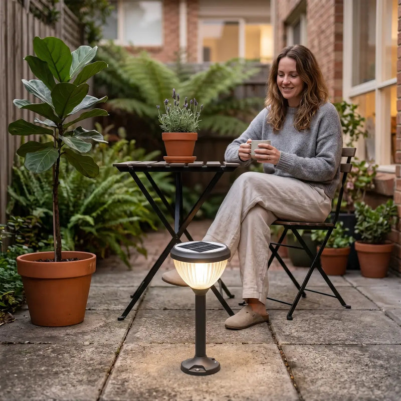Woman sitting outdoors with a solar lamp and plants