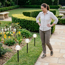 Woman standing in a garden with solar lights on grass