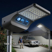 T008 vs T007 solar street light comparison at night with T008 showing 82 percent battery on LED screen and man standing beside SUV in driveway