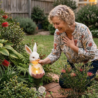 Woman interacting with a rabbit-shaped garden light in a garden setting