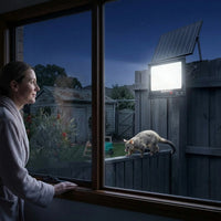 Woman in bathrobe looking out window at night, T001ES solar light on fence illuminating a possum walking along the fence rail in the backyard. Demonstrates microwave sensor detecting animal movement in dark garden.