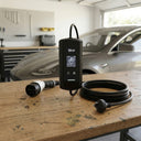 Car charging cable and adapter on a wooden table with a car in the background.Safety certifications for Flaro Portable EV Charger including RCM and IP65