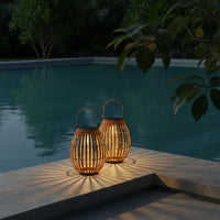Two illuminated solar garden lawn light by a pool at night