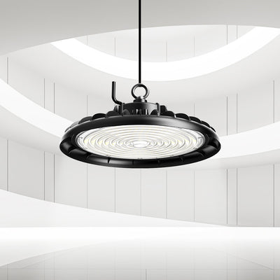 Black LED light high bay fixture hanging in a modern interior setting with white walls.