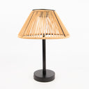 Solar table lamp with a wicker shade and black base on a white background