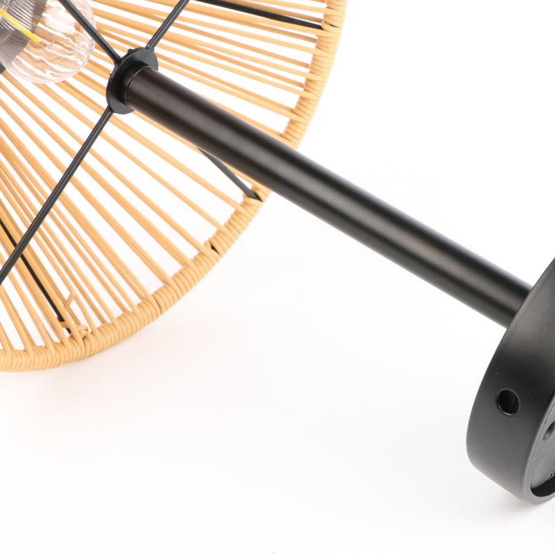 Close-up of a modern pendant light with a black metal rod, circular black finial, and a natural woven rattan shade on a white background.