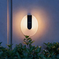 A solar wall light mounted on a wall, illuminating the surrounding area with a warm glow.