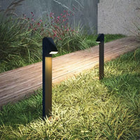 Garden path with two black outdoor solar pathwaylights illuminating grass and flowers.