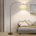 Elegant arched floor lamp next to sofa in living room.