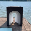 Stylish solar lamp adds ambient light to modern patio.