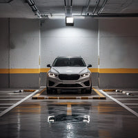 car illuminated by an LED floodlight in a garage setting.