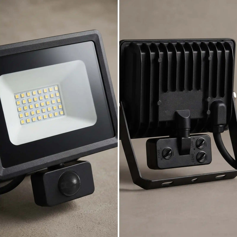 A split-view product photo of a black outdoor LED floodlight with a mounted motion detector. The left side shows the front face with the illuminated LED grid, and the right side shows the back with cooling fins, mounting bracket, and power connector.