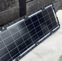 A solar panel placed on a table, designed for use with a solar sensor floodlight.