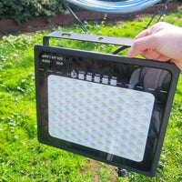 Individual displaying a solar sensor floodlight, emphasizing its eco-friendly lighting solution for outdoor spaces.